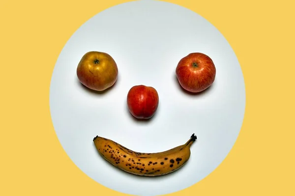 minimalist round fruit face made of apple, peach and banana