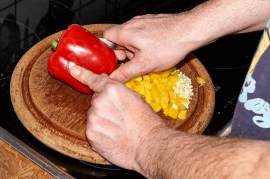 Sarı ve kırmızı biber biber bir gemide bir bıçak ile kesmek