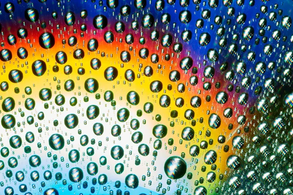 Macro de gotas de agua sobre fondo multicolor — Foto de Stock