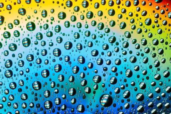 Macro de gotas de agua sobre fondo multicolor — Foto de Stock