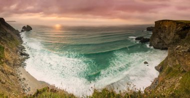 Basset Cove Cornwall, İngiltere 'de yaz günbatımında çekilen panoramik bir çekim.