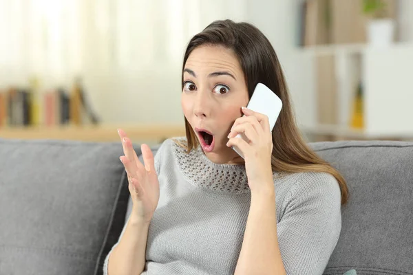 Mujer Sorprendida Teléfono Mirando Cámara Sentada Sofá Sala Estar Casa —  Fotos de Stock