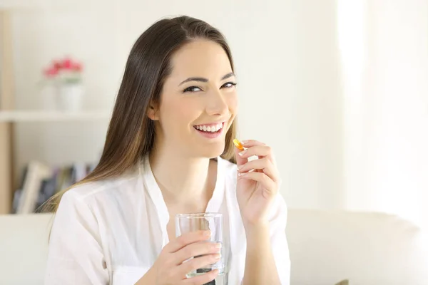 Donna Felice Che Prende Una Pillola Integratore Vitaminico Guardandoti Seduta — Foto Stock