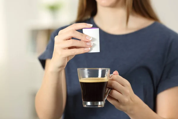前视图关闭一个女人的手扔糖精到咖啡杯在家里 — 图库照片