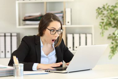 Bir masaüstü bilgisayarda iyi haber okumak hayrete ofis çalışanı
