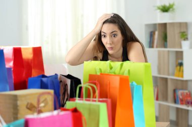 Sürpriz kadın renkli alışveriş torbaları evde birden fazla satın bakarak