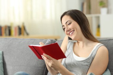 Kadın telefon oturma odasında evde bir kanepede oturan sırasında gündem not alma
