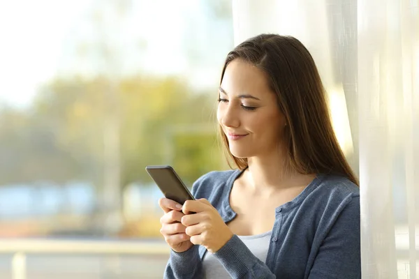 Mulher Feliz Usando Smartphone Lado Uma Janela Casa — Fotografia de Stock