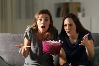 Oturma odasında evde bir kanepede oturan gece TV izlerken boşa çıkarmak arkadaş