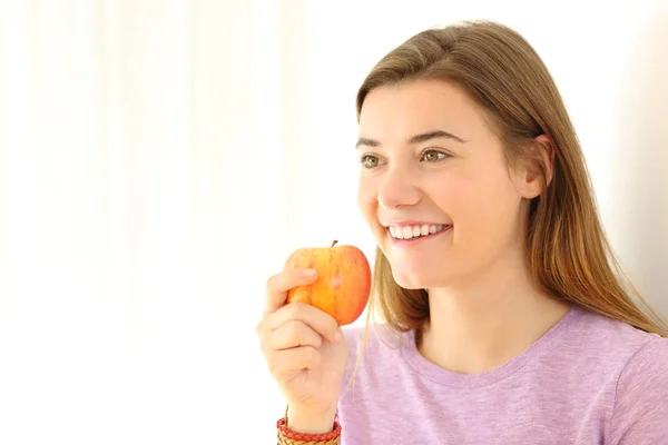 Lycklig Tonåring Holding Ett Äpple Som Tittar Bort Vit Sida — Stockfoto