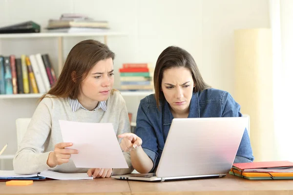 Dua Siswa Terkonsentrasi Membandingkan Dokumen Kertas Online Dengan Laptop Rumah — Stok Foto