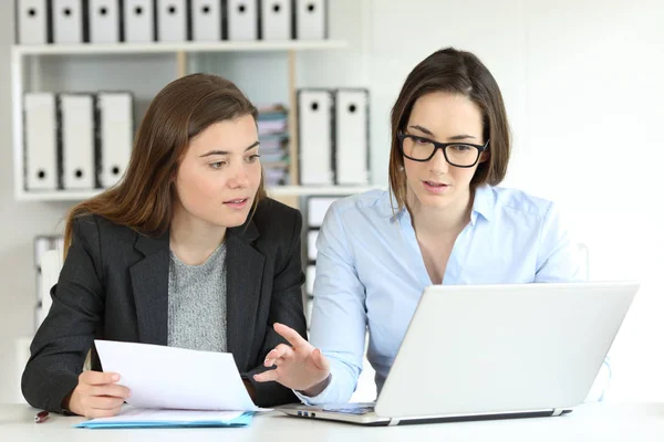 Två Koncentrerade Kontorsarbetare Jämföra Pappersdokument Line Med Bärbar Dator — Stockfoto