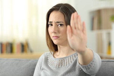 Üzgün kadın oturma odasında evde bir kanepede oturan el ile el hareketi reddetme