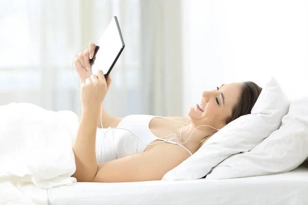 Happy Girl Menonton Online Dengan Tablet Dan Earphone Tempat Tidur — Stok Foto