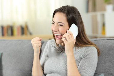 Heyecanlı kadın oturma odasında evde bir kanepede oturan telefon sohbet