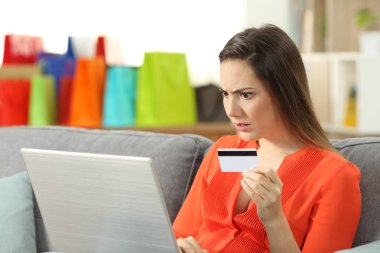 Şok alışveriş oturma odasında evde bir kanepede oturan kredi kartıyla online satın alma