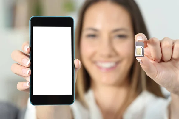Sim カードとスマート フォンを示す幸せな女の手のクローズ アップ — ストック写真
