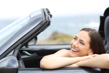 Mutlu sürücü yan cabriolet otomobil sahilde bakarak tatil keyfi