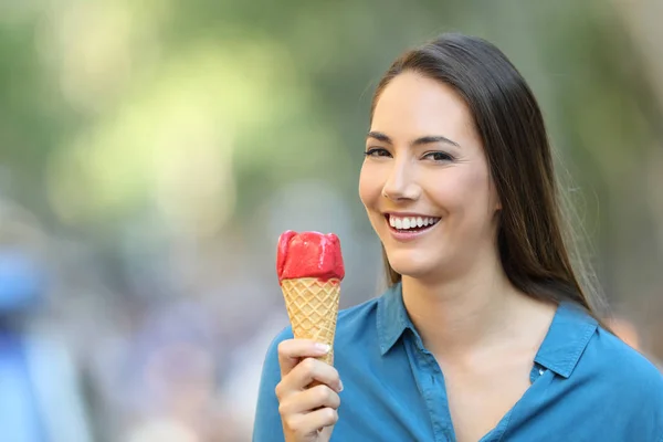 路上であなたを見てアイスクリームを保持している幸せな女性の肖像画 — ストック写真