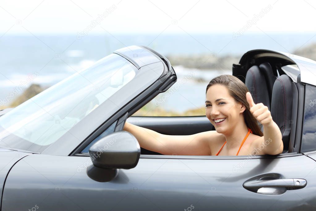 Convertible car driver with thumbs up driving on summer vacation