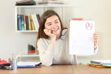 Kamera için onaylanmış bir sınav evde gösterilen memnun öğrenci