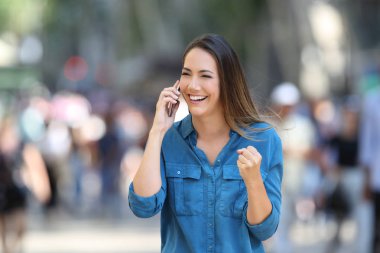 Heyecanlı kadın sokakta telefon üzerinde iyi haber alma