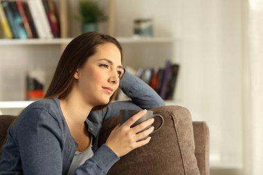 Rahat Bayan oturma odasında evde bir kanepede oturan bir pencereden bakarak düşünüyorum