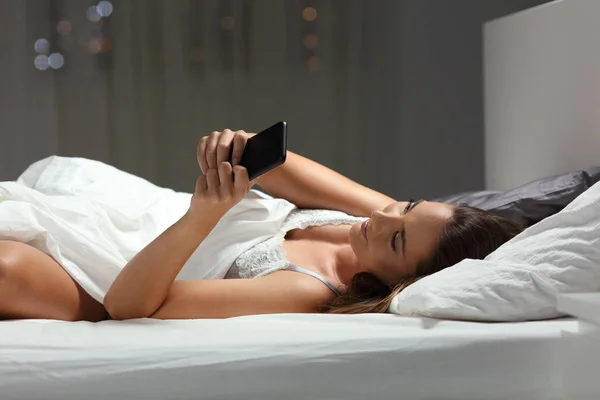 Розслаблена Жінка Використовує Смартфон Вночі Ліжку Вдома — стокове фото