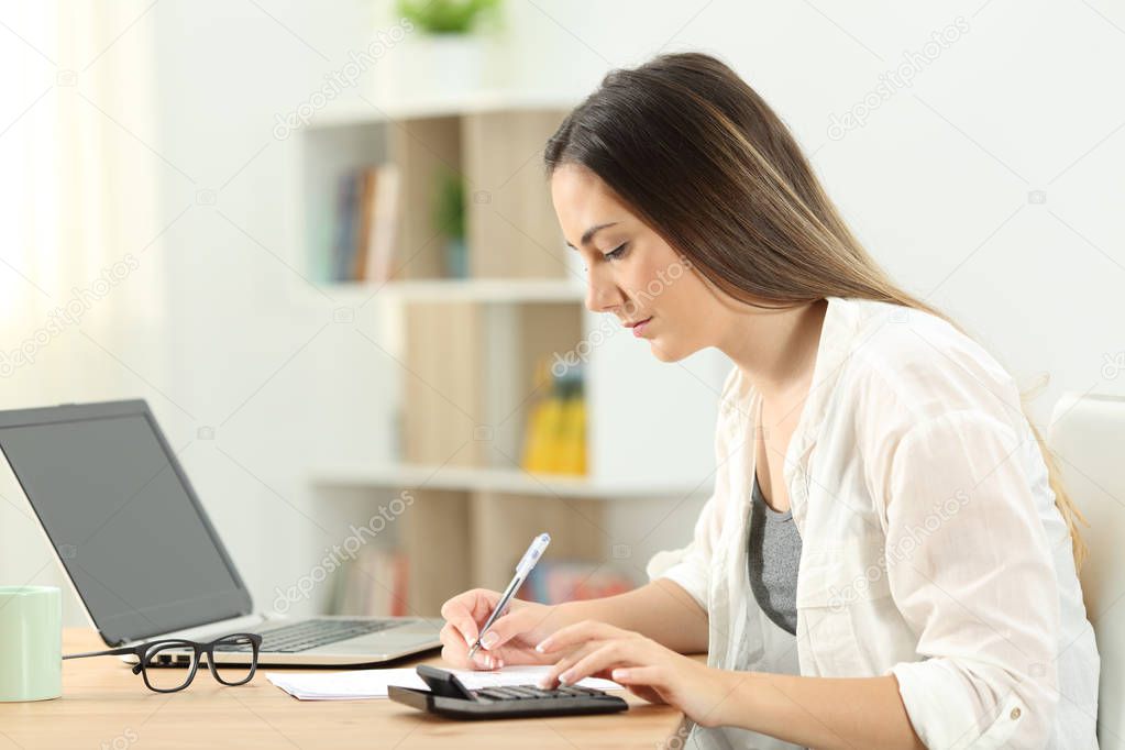Side view portrait of a serious woman doing accounting at home