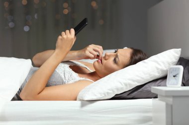 Sinir kadın gece evde bir yatakta telefon mesajı okuma