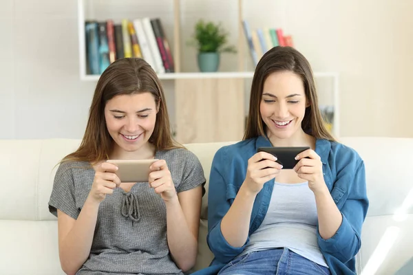 Двоє Друзів Грають Онлайн Ігри Смартфонами Сидячи Дивані Вітальні Вдома — стокове фото