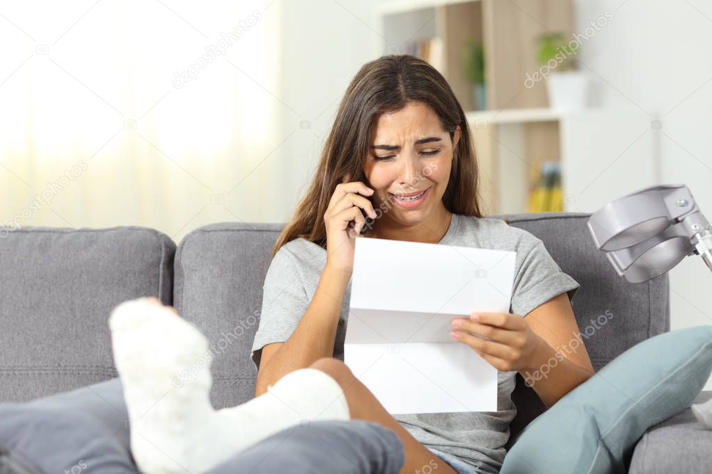 Sad disabled girl receiving bad news sitting on a couch in the living room at home
