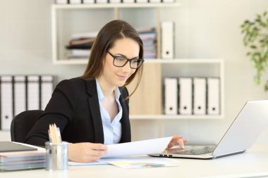 Çevrimiçi çalışıyorsanız bir dizüstü bilgisayar ile bir masa üzerine gözlük takıyor ofis çalışanı
