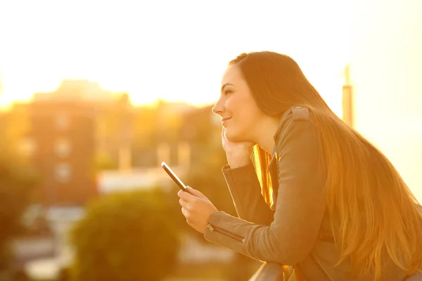 Side View Portret Dziewczynki Zamyślony Posiadania Telefonu Zachód Balkon Dom — Zdjęcie stockowe