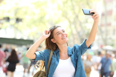 Alma selfies sokakta bir akıllı telefon ile gülümseyen kız moda
