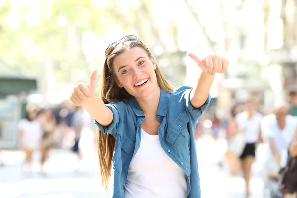 快乐的女孩示意大拇指在街上看相机 — 图库照片