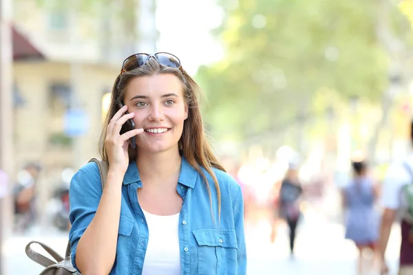 通りにコピー スペースと電話で話しているカメラに向かって幸せな女の正面肖像画 — ストック写真