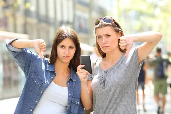 Sokakta Bir Akıllı Telefon Başparmak Ile Basılı Iki Kızgın Arkadaş — Stok fotoğraf