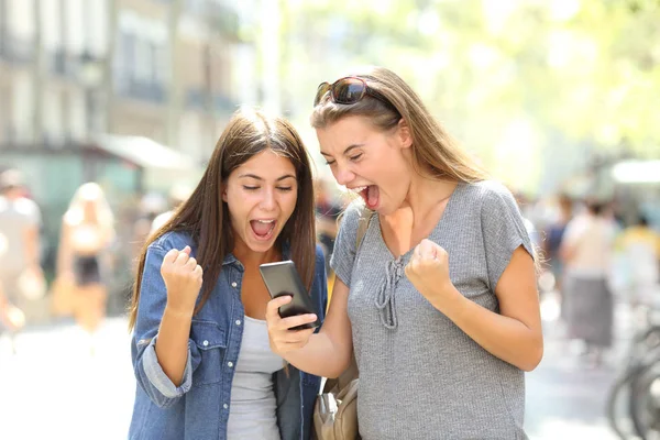 Dua Pemenang Bersemangat Menonton Konten Online Ponsel Pintar Jalan — Stok Foto