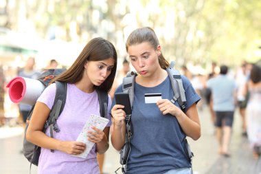 Karışık backpackers bir kredi kartı ve bir akıllı telefon ile online pahalı ürün satın alma