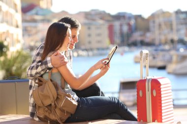 Yan görünüm portre pf mutlu çift tatilde bir tablet danışmanlık turist