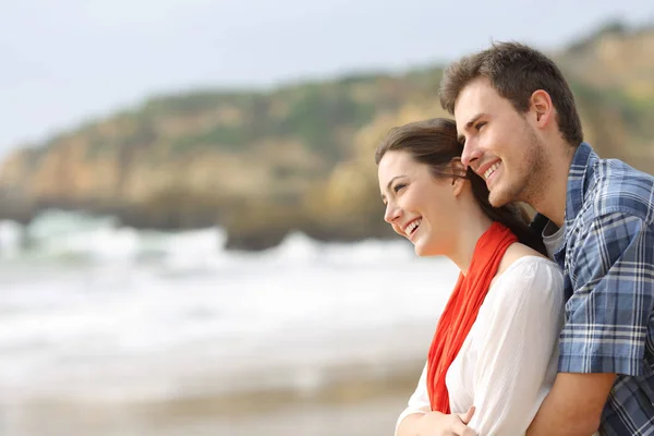Side View Portret Szczęśliwa Para Przytulanie Patrząc Horyzoncie Plaży — Zdjęcie stockowe