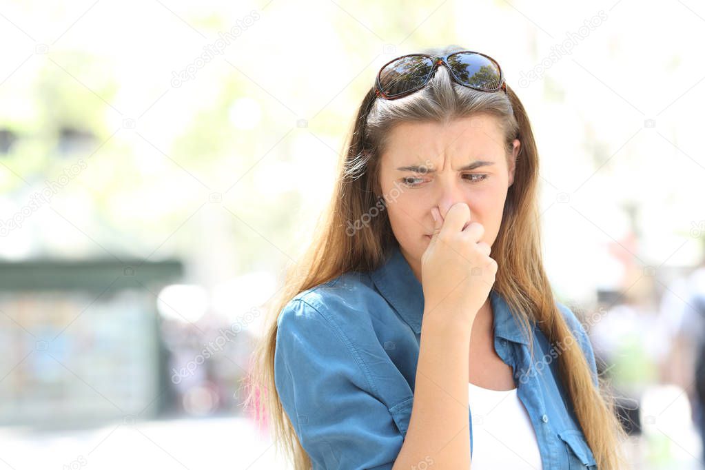 Girl covering nose in the middle of a contaminated city street