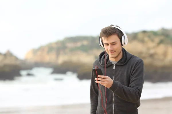 편안한 헤드폰와 해변에 스마트폰 음악을 — 스톡 사진