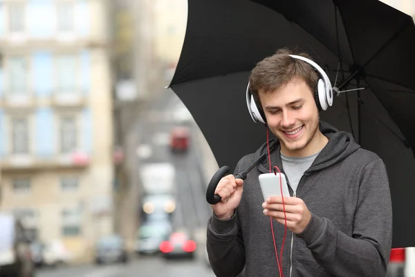 Joyeux Adolescent Écouter Musique Avec Téléphone Intelligent Écouteurs Sous Pluie — Photo