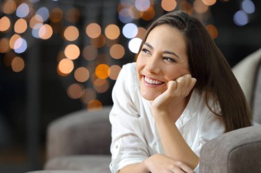 Kadın evde oturma odasında kanepede yatan gece yanında seyir düşünüyorum