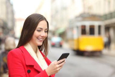 Kırmızılı bir şehir eski kasabada bir akıllı telefon kullanarak mutlu kadın