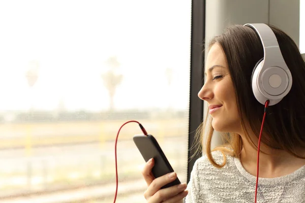 スマート フォンとヘッドフォンで音楽を聴く列車旅行幸せな通勤 — ストック写真