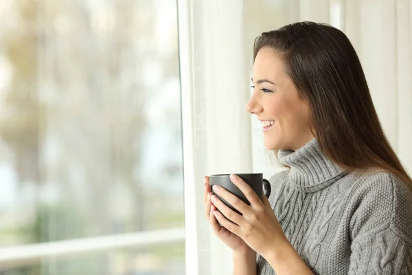自宅の窓から外を見てコーヒーを飲んで幸せな女像側ビュー — ストック写真