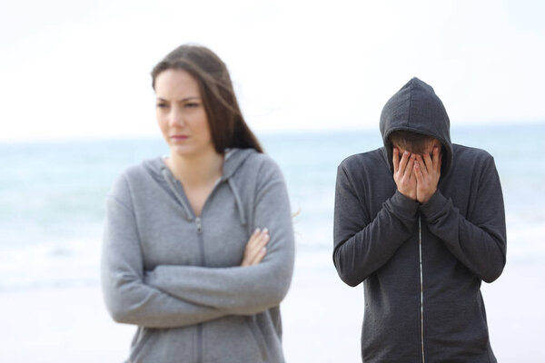 Couple break up on the beach with a girl leaving man alone